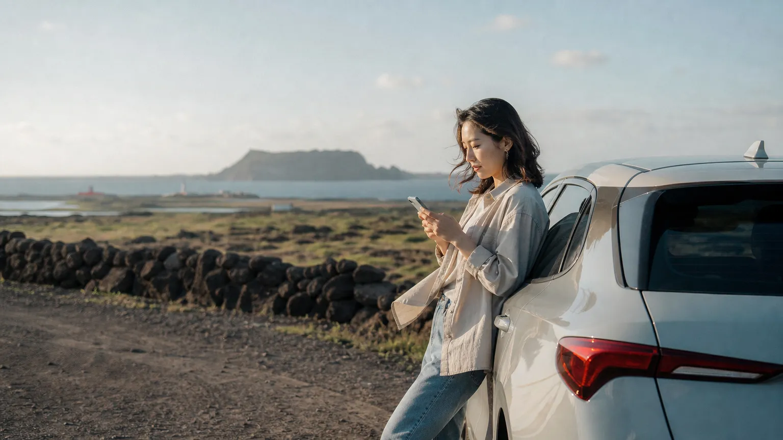 Person checking a phone beside a car